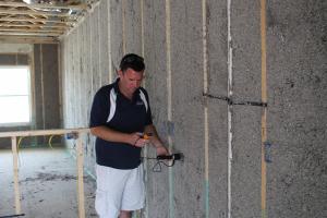 Moisture levels are checked in the blown cellulose insulation before enclosing the walls.