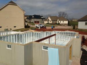The basement is constructed with precast concrete walls lined with R-21.3 foil-faced rigid foam while an R-10 layer of XPS rigid foam covers the ground under the slab.