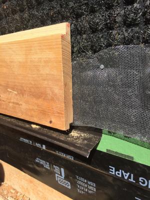 The metal screening keeps insects out of the black mesh plastic fabric which provides a ventilation gap behind the home’s siding, which includes the ship-lapped cypress shown here.