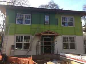 A mesh plastic rainscreen product separates the coated OSB from the siding, providing a drainage space and ventilation gap.