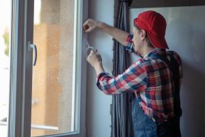 Installation of weatherstripping on a window.