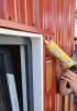 Exterior window frame being caulked with a caulking gun.