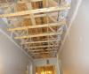This air-sealing approach uses the wall drywall to isolate the corridor from the individual units in a multifamily building that has a truss floor structural system