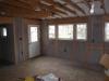 Drywall was removed and the existing 2x4 walls were filled with 3.5 inches of dense-packed cellulose. Outside, the ½-inch plywood was topped with house wrap, 1.5 inches closed-cell rigid foam, 1x3 furring strips, and fiber cement siding.