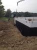 Concrete is poured into the rigid foam shell of the insulated concrete form (ICF) walls; a plastic water barrier has already been installed to protect the below-grade wall surfaces.