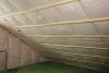 Underneath the roof sheathing and two exterior layers of rigid foam, the builder stapled netting to the underside of the rafters and filled the roof cavities of the unvented attic with blown-in fiberglass insulation.