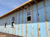 Over the taped rigid foam board, 2x4 furring strips provide a ventilating air gap and drainage plane under the engineered wood lap siding. The furring strips were attached with structural screws to provide an attachment surface for the siding.
