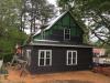 The builder installed a rain screen product that provides an air gap and drainage plane between the coated OSB sheathing and the cladding; the fabric layer folded over the bottom edge forms an insect screen. 