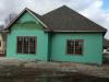 Two types of paint-on flashing (green and red) are installed on the walls and around the windows, over the coated sheathing which is taped at the seams.
