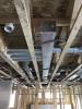 Right – The hard metal ducts are located in conditioned space between floor joists and all seams are sealed with approved metal tape.