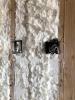 Right – Spray foam completely fills the wall cavities, providing a thorough layer of insulation behind electrical boxes.