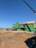 Right – This home’s above-grade walls are constructed in a factory where wall panels of 2x6 studs are assembled and sheathed with a coated OSB product, then windows are installed and flashed before shipping the panels to the site for assembly by crane. 