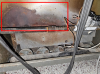 This furnace exhibits signs that it has backdrafted in the past, including soot marks on the sheet metal outside of the burner tubes.