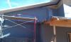A liquid-applied water barrier covers the walls, serving as a drainage plane, air and vapor barrier, and secondary window flashing beneath the rigid foam that will be installed next.