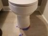 Wrong - Cardboard should be removed from under toilet base.