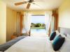 This room has several passive and low-energy cooling features including a ceiling fan, fully operable French doors, window shading, an outdoor water feature, and light-colored hard-scaping.
