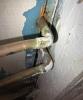 The gaps in the subfloor around these copper plumbing pipes should be caulked to protect the conditioned space from air infiltration 