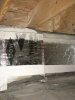 Right - This unvented crawlspace is insulated along the walls and between the floor joists with 2-inch foil-faced polyisocyanurate; a termite inspection gap is visible above of the wall insulation and below the band joist.