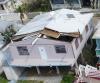High winds pulled part of the roof off this gable-roofed home.