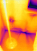 This IR camera image shows air leakage indicated by the dark purple streaks along the bottom plates and below the window sill, as well as some heat loss at the electric outlet. 