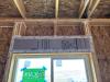 This window header has been insulated with rigid foam and air sealed with house wrap tape and all wood-to-wood joints are caulked.