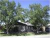 Large deciduous trees provide heat-blocking shade to the walls and windows of this house.