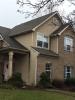 Wrong - Missing kick-out flashing to divert rainwater runoff away from the house and into the gutter where the roof meets the wall has caused discoloration of the stucco and water damage behind the stucco by the front porch and the second-story window. 