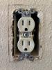 The cover plate has been removed from this outlet, exposing the gap between the electrical box and the drywall.