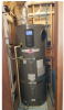 Right: This heat pump water heater is installed in a small space so the, intake air is ducted from an adjacent room; the water heater since on a pad of foam insulation and has a good drain line configuration but the waterpipes lack insulation