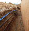 Foundation heat exchanger installed in overcut around a basement wall