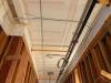 The ceiling and sides of this corridor service chase in a multifamily building are air-sealed with mudded and taped drywall prior to installing pipes, wiring, and ducts.
