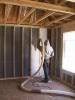 Blown fiberglass insulation fills netted wall cavities 