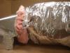 Wrong- A tie strap should not be used over the duct outer liner because it can compress the insulation. Tuck in the fibrous insulation and seal the outer liner to the connecting duct with mastic or foil tape (Steven Winter Associates 2013).