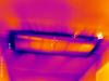 The dark streaks seen in this infrared camera image of a return vent in a ceiling indicate cooler air is leaking in around the vent.