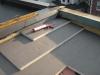 Polyisocyanurate rigid foam insulation is installed in multiple layers with staggered, taped seams over the flat roof