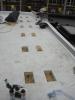 Roofing membrane is installed over polyisocyanurate rigid foam insulation and insulation cover board that has been cut to fit around locations for blocking for the PV system rack