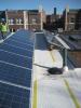 The retrofitted flat roof has PV panels and walking mats installed over the roofing membrane