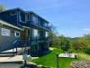 These wildfire-resistant decks have a solid decking surface, metal railings, and the underside timber supports are covered with flame-resistant fiber cement board; also the decking is set back from the vegetated slope. 