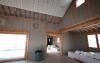 Sheets of phase-change material are installed over the cellulose insulation to help even out interior temperatures.