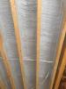 Spray foam insulation air-seals and insulates the floor above the garage; the joist will be filled with fibrous insulation in this flash-and-batt approach.