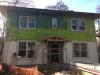 A mesh plastic rainscreen product separates the coated OSB from the siding, providing a drainage space and ventilation gap.